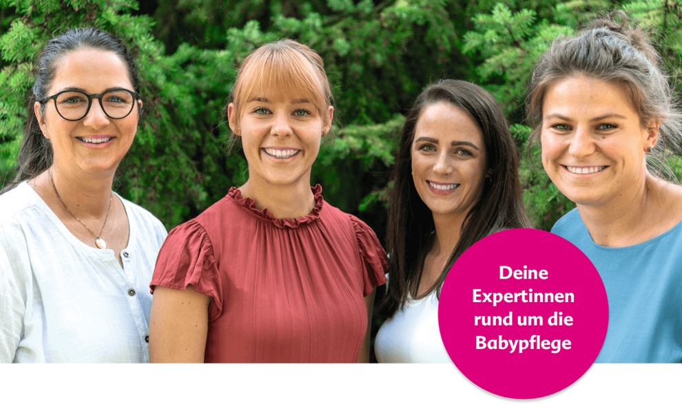 Vier Frauen stehen im Freien vor einer grünen Kulisse. Eine der Frauen hält einen rosa Kreis mit der Aufschrift "Deine Experten rund um die Babypflege".