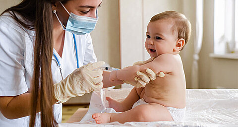 Eine medizinische Fachkraft, die einem Baby einen Impfstoff verabreicht.
