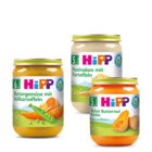 Drei Gläser Babynahrung mit der Aufschrift "Hipp", die jeweils unterschiedliche Zutaten wie Karotten, Erbsen und Butternusskürbis enthalten.