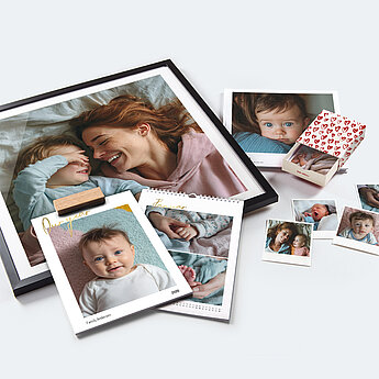 Eine Sammlung von Fotografien und Karten, auf denen hauptsächlich Babys und eine Frau abgebildet sind, wobei eine Karte den Namen eines Babys und eine herzförmige Verzierung aufweist.